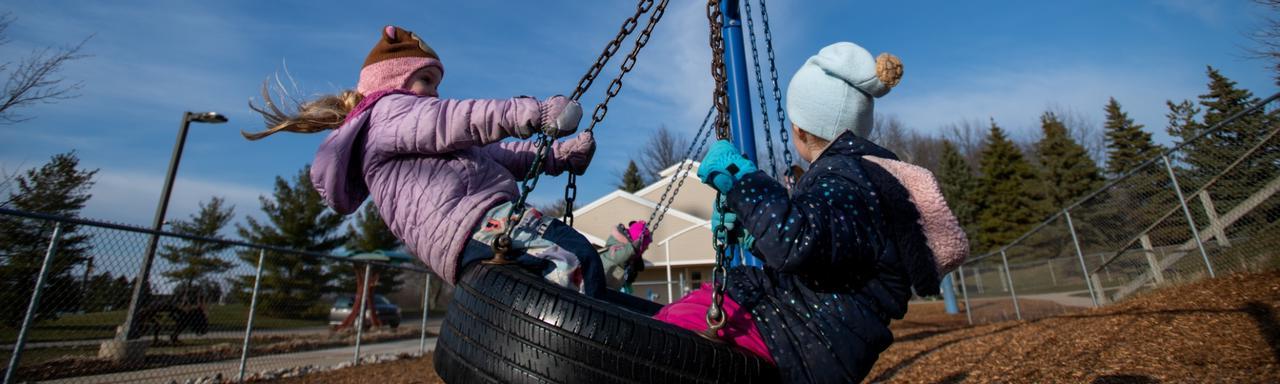 kids swinging on a tire swing